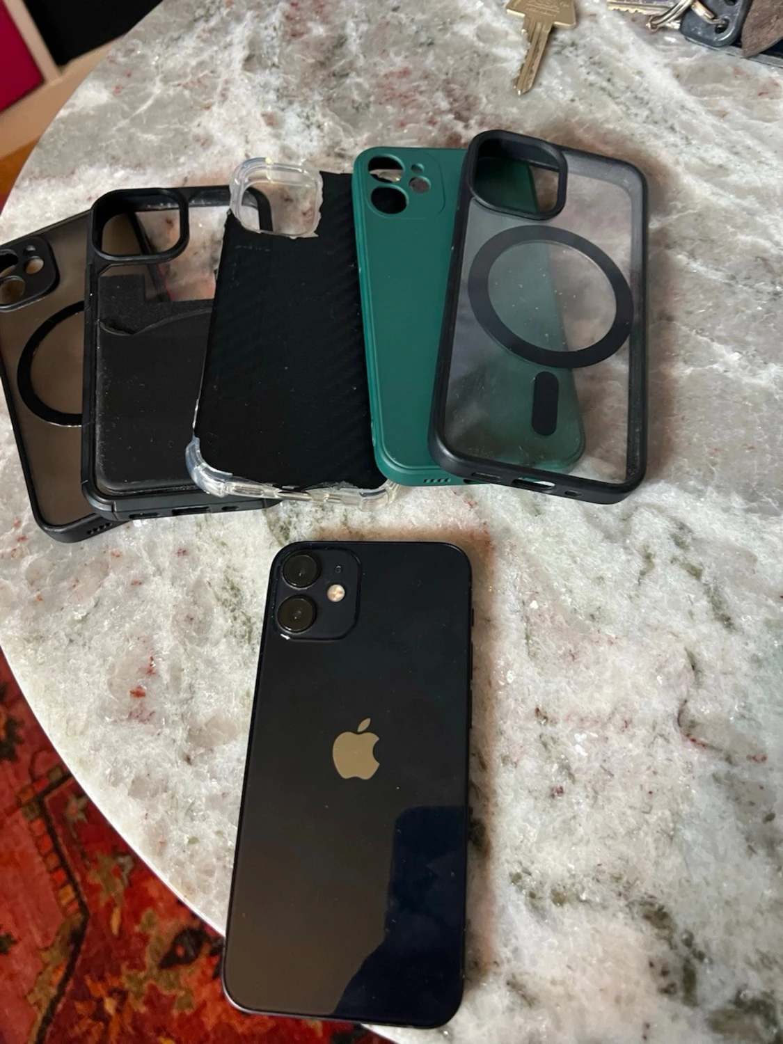 Svart iPhone 12 mini med flera skal