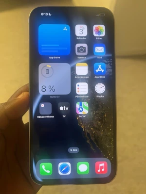 Silverfärgad iPhone med platt ram - Säljer en silverfärgad iPhone med platt ram och stor skärm. Baksidan är i glas och har tre stora kameralinser samt Apple-loggan. Telefonen har en modern design med rundade hörn och metallram. Perfekt för dig som gillar stilren teknik och vill ha en kraftfull smartphone.