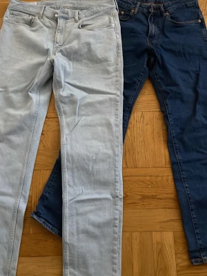 Två par jeans från Regularfit - Säljer två par jeans från Regularfit, ett par i ljusblå tvätt och ett par i mörkblå tvätt. Båda har klassisk femficksdesign, raka ben och normal midja. Perfekta för en avslappnad och trendig look. Materialet är bomullsdenim.
