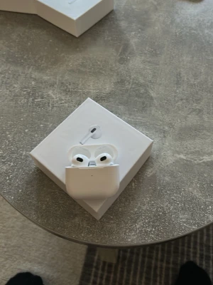 Apple AirPods 3 trådlösa hörlurar - Säljer ett par Apple AirPods 3 i originalförpackning. De är vita, har en stilren och kompakt design och är tillverkade i plast. Perfekta för musik, samtal och träning med smidig anslutning till iPhone och andra Apple-enheter.