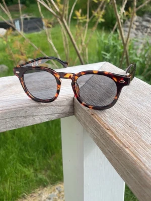 Runda solglasögon i leopardmönster - Snygga runda solglasögon med leopardmönstrad båge i bruna och gula toner. Klassisk modell som ger en cool vibe till din outfit. Perfekta för soliga dagar och festivalhäng.