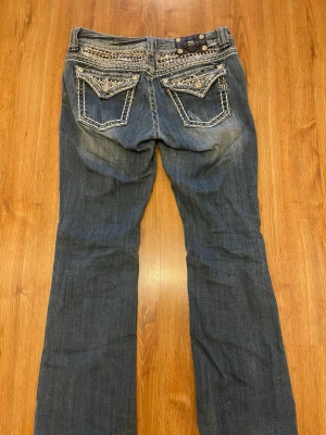 Miss Me Jeans - Snygga mörkblå bootcut jeans från Miss Me. Bra skick förutom att det är klippt i innersömmen vid knappen, det är draget ett snöre där då de varit förstora i midjan för mig. Inget som syns och snöret kan dras ur (syns på bilden). 84 cm midjemått, 76 cm innerbenslängd. Pris kan diskuteras⭐️