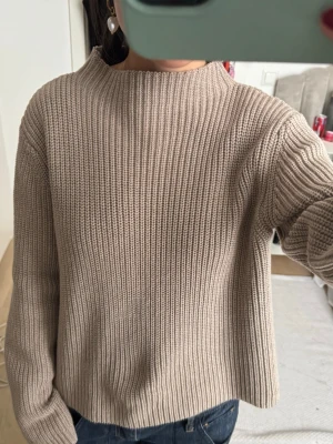 Beige ribbstickad tröja - Säljer en beige ribbstickad tröja med hög hals och långa ärmar. 