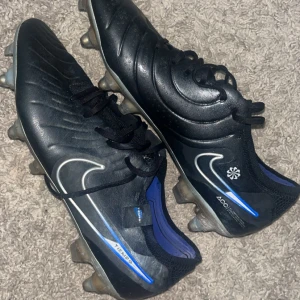 Nike Tiempo svarta fotbollsskor - Säljer ett par svarta Nike Tiempos med anticlog/skruv dobbar och läder på ovandelen. Väldigt sköna skor och bra fäste för dig som vill slippa risken att halka på fotbollsplan. Nypris 2349kr släpper dom för 700kr slå en pling!