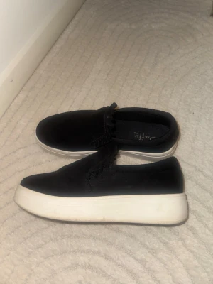 Duffy sneakers - Svarta slip-in sneakers från Duffy, strl 39  Använda men i fint skick, undersidan som är rätt smutsig bara
