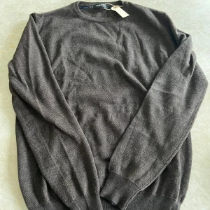 Mörkbrun stickad tröja från Sand - Säljer en mörkbrun stickad tröja från Sand i storlek M. Den är i bra skick utan defekter. Pris 300kr.