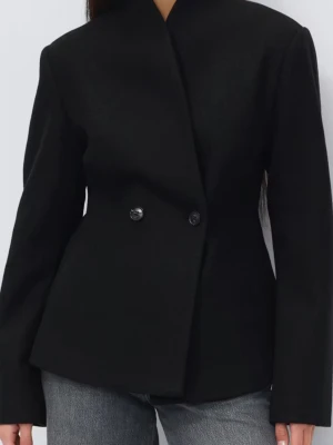 Svart figursydd kavaj med knappar - Stilren svart kavaj med figurnära passform och dubbelknäppning framtill. Kavajen har en hög krage och långa ärmar, vilket ger en modern och elegant siluett. Perfekt att matcha med jeans eller kostymbyxor för en trendig look. Helt ny med prislapp på 