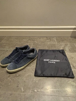 Blå Saint Laurent sneakers i mocka - Säljer ett par jättefina blåa Saint Laurent skor i mycket bra skick. Lite slitage på insidan som inte märks.