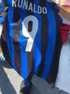 Inter Ronaldo matchtröja Nike S - Säljer en klassisk Inter Milan matchtröja från Nike med RONALDO och nummer 9 på ryggen. Tröjan har blå och svarta ränder, Pirelli-logga på bröstet och klubbmärke. Perfekt för dig som älskar fotboll och retrostil.