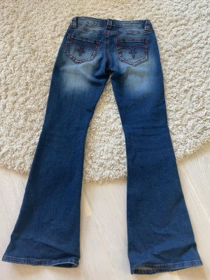 Mörkblå bootcut jeans från Gina - Säljer ett par superfina mörkblå jeans. Jeansen har utsvängda ben och sitter snyggt över höfterna. Perfekta till sneakers eller boots. Materialet är mjukt denim med lite stretch. Säljer då de är lite små.
