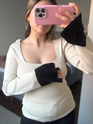 Beige ribbad tröja med vida ärmar - Säljer denna beiga ribbade tröjan med utsvängda ärmar och svart rand. Endast använd en gång💕