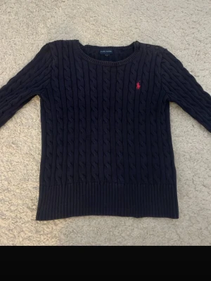 Mörkblå kabelstickad tröja Polo Ralph Lauren - Annars bra skick förutom att den har ett litet hål vid sidan av nacken som syns på bild 2. St S (8-10) i barn! Pris kan diskuteras💕