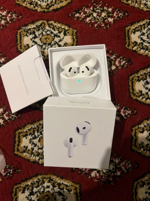 Apple AirPods 4 med brusreducering - Säljer ett par vita Apple AirPods 4 med aktiv brusreducering. De har en stilren och kompakt design med laddningsetui i hårdplast. Perfekta för trådlös musik och samtal, och kommer i originalförpackning med tillhörande manual.