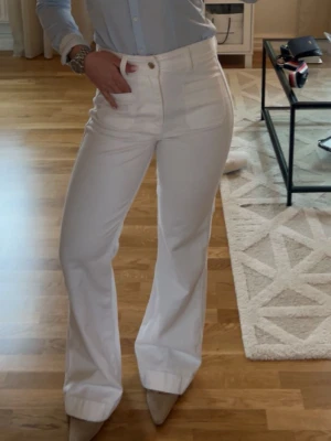 Vita vida jeans med hög midja - Säljer ett par vita jeans med hög midja och bootcut 