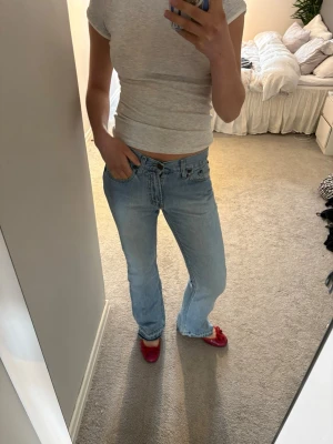 Ljusblå bootcut jeans - Säljer ett par ljusblå bootcut jeans med låg midja och klassisk femficksdesign. Jeansen har en avslappnad passform och är perfekta för i sommar. Materialet är denim i bomull och de har en snygg tvättad look❤️‍🔥