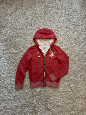 Röd Abercrombie & Fitch zip hoodie - Riiiiktigt snygg hoodie från Abercrombie and fitch. Hade inte sålt den om den passade mig, storlek S. Använd men i bra skick, tveka inte på o skriva vid fler frågor!