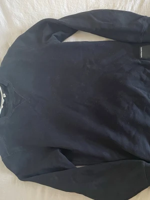 Svart sweatshirt från Björn Borg - En enkel svart sweatshirt från Björn Borg med rund halsringning och långa ärmar. Tröjan har en klassisk passform och ribbade muddar vid ärmslut och nederkant. Perfekt basplagg för din garderob.