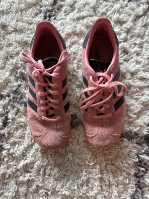 Rosa Adidas sneakers med mocka - Rosa Adidas sneakers i mocka med svarta ränder på sidorna och gummisula. Nästan aldrig använda.