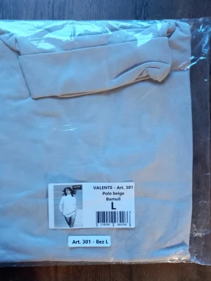 Beige polotopp från Valente storlek L  - Säljer en beige polotopp från Valente i mjuk bomull. Toppen har klassisk polokrage och är perfekt för dig som gillar stilrena och enkla plagg. Passar till allt och är superenkel att matcha med andra kläder. Storlek L 