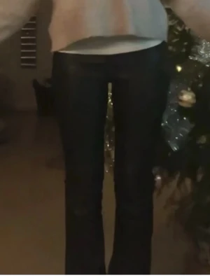 Svarta utsvängda jeans - Säljer ett par svarta skinn byxor som nya 