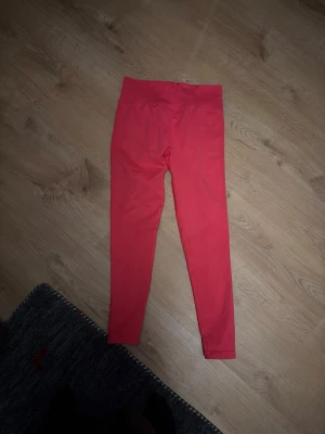 Mörk Rosa leggings från ICANIWILL oanvänt  - Snygga rosa leggings från ICANIWILL i storlek M. De har hög midja och är tillverkade i ett stretchigt material som sitter skönt på kroppen. Perfekta för träning eller en chill dag. Färgen är starkt rosa och materialet känns mjukt och följsamt.