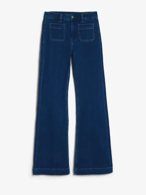 Mörkblå utsvängda jeans med fickor - Säljer ett par mörkblå jeans med utsvängda ben och stora fyrkantiga fickor både fram och bak. Jeansen har hög midja och klassisk knappgylf. Materialet är bomull och passformen är normal. Perfekta för dig som gillar retrovibbar och stilren look.