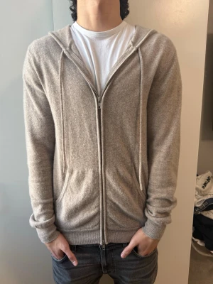 John Henric 100% cashmere tröja - Säljer en beige hoodie med dragkedja och huva från John Henric, 100% cashmere. Den är nyskick använd max 4 gånger och inga defekter. Storlek M. Nypris-3000kr mitt pris-1300kr