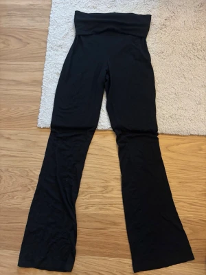 Svarta utsvängda yoga pants  - Säljer ett par svarta yoga pants med utsvängda ben. De är stretchiga och sitter skönt på kroppen, perfekta för en avslappnad och trendig look. Materialet känns mjukt och följsamt.
