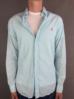 Ralph Lauren skjorta - Ralph Lauren Skjorta Märke: Polo Ralph Lauren Storlek: M Passform: Slimfit Färg: Blåvit randig Skick: Bra Beskrivning: Tunnare skjort material, bortklippt tvättlapp Modellen på bilden: 183 cm / 74 kg