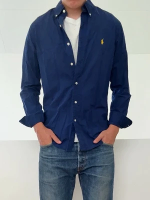 Mörkblå Ralph Lauren skjorya - Mörkblå Ralph Lauren skjorta i strl M men passar även S! Bra skick utan nåra defekter och hör gärna av er vid frågor elr funderingar!!