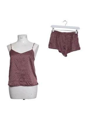 Mönstrad pyjamassats med linne och shorts - Säljer ett snyggt pyjamasset bestående av ett linne med tunna axelband och matchande shorts. Setet är vinrött med ett småmönstrat tryck i vitt och svart. Materialet ser ut att vara mjukt och glansigt, perfekt för mysiga kvällar hemma.