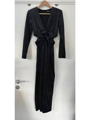 ZARA Svart långklänning med glittrigt mönster - storlek M - Stilren lång klänning i sammet med rutigt mönster i glittrig silvertråd från ZARA i storlek M. Trending modell med långa ärmar, smickrande V-ringning och utskurna detaljer i midjan som framhäver figuren. Dold dragkedja bak, diskreta axelvaddar och en elegant slits nedtill bak för ökad rörlighet. Otroligt fin festklänning som är smickrande för alla kroppsformer. Mycket fint skick, som ny!