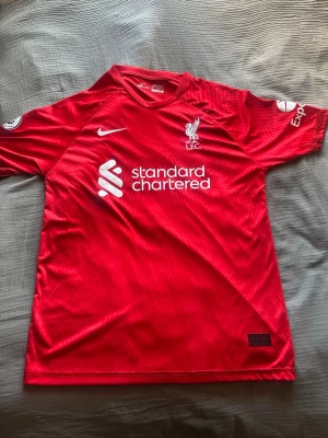 Liverpool Nike matchtröja röd - Säljer en röd Liverpool matchtröja från Nike med tryck 'VIRGIL 4' på ryggen. Tröjan har vita loggor, klubbmärke och sponsortryck på bröstet samt detaljer på ärmarna. 