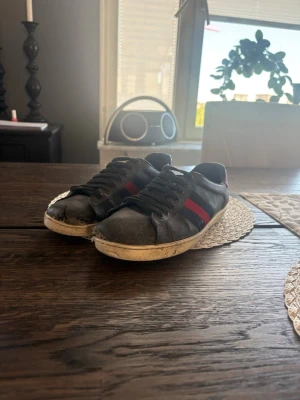 Svarta sneakers med röd/blå detalj - Bra slitna men går o använda och säkert o fixa upp 