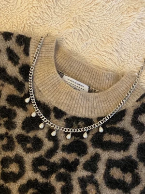 Silverfärgat halsband med pärlor - Snyggt halsband i silverfärgad rostfritt med kedja och hängande vita pärlor. Kedjan har en klassisk, lite chunky look och pärlorna ger en elegant touch. Perfekt för att lyfta vilken outfit som helst.