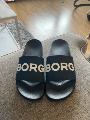 Svarta tofflor från Björn Borg - Säljer ett par svarta tofflor från Björn Borg, använd en gång!