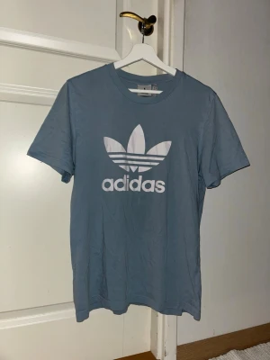 Blå Adidas t-shirt med logga - Ljusblå adidas t-shirt med loggan tryckt på framsidan, Storlek S
