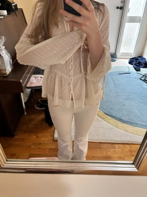 Vit prickig blus från Zara - Söt vit blus från Zara i transparent, lätt material med små broderade prickar. Blusen har v-ringning, knappar framtill och volang nedtill. Långa ärmar med lös passform och tunna knytband. Dne är helt ny med prislapp från Zara i storlek xs, köptes för 379kr💘😊