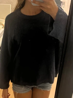 Mörkblå stickad tröja från 157 - Mysig mörkblå stickad tröja från 157 i storlek XS. Tröjan har en avslappnad passform med rund halsringning och långa ärmar och ger en oversized look. Tröjan är lite nopprig