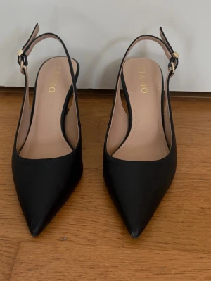 Svarta klackar - Jättefina slingback klackar från Tiamo.  Har använt dom en gång men säljer tyvärr då dem är förstora för mig.  Dem har lite slitage längst ner på klackarna och lite längst fram vid tån men annars är dom som nya (3 sista bilderna).  Har tvättat dom helt efter användning och lådan finns ifall man vill ha💕 Pris går alltid att diskutera!⭐️