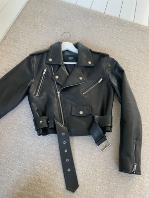 Svart skinnjacka från Bik Bok XS - Säljer min supersnygga skinnjacka i storlek xs i helt nytt skick, använd nån enstakad gång, därav inga defekter! Köptes för 500 kr på bikbok men säljer endast för 150kr, kan tänka mig att gå ner till 100kr! 