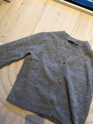 Grå kofta med knappar från H&M - Mysig grå kofta från lager 157 med tre stora knappar framtill. Super fin och inte använd alls mycket.