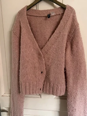 Rosa stickad kofta från H&M - Mysig rosa stickad kofta från H&M med v-ringning och knappar framtill. Inga defekter. 