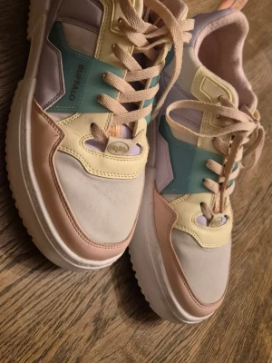 Pastellfärgade sneakers från Buffalo strl 41 - Snygga sneakers från Buffalo i pastellfärger med inslag av ljusgul, ljusrosa, mintgrön och lila. Skorna har chunky sula, klassisk snörning. Perfekta för dig som vill sticka ut med färg och stil. Veganska. Använd fåtal gånger, modellen passar tyvärr inte min fot.