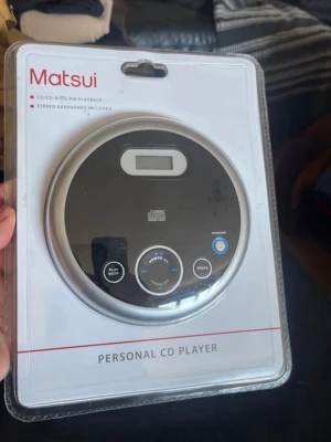 Matsui personlig CD-spelare - Snygg och kompakt personlig CD-spelare från Matsui i svart och silver. Spelaren har LCD-display, knappar för play mode, random och program samt medföljande stereo hörlurar. Perfekt för dig som vill lyssna på CD-skivor på språng.