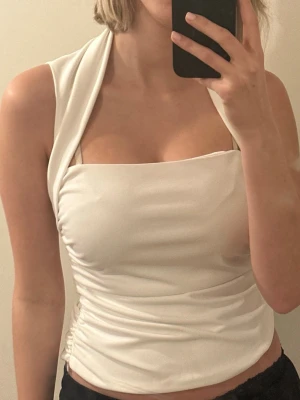 Vit halterneck topp.  - Säljer en snygg vit halterneck topp. Setchigt, mjukt material som sitter tight mot kroppen. Perfekt till sommarens outfits och enkel att styla. Från ZARA.