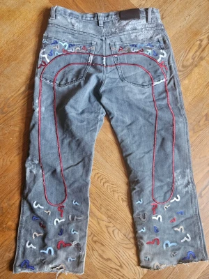 Evisu Genes - Riktigt feta, ovanliga, Evisu Genes jeans. De e bootcut men sitter ganska baggy, trots att de ska vara 32 passar de mig som har 34 i midjan. En del repairs men proffsigt gjorda av skräddare. Hör av er så löser vi en bra deal🤝🤝 
