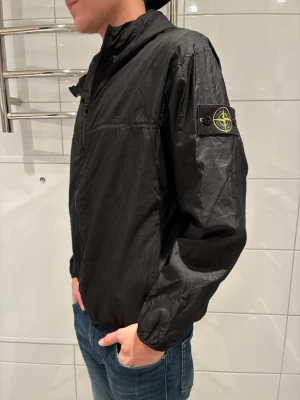 Svart vindjacka från Stone Island - Säljer nu denna ruggigt snygga stone Island vindjackan perfekt för våren och sommaren. Den är i väldigt fint skick då den enbart är använd ett fåtal gånger. Tveka inte på att höra av er vid minsta funderingar🙌