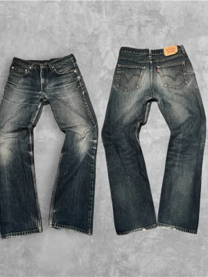Vintage Levi’s jeans - Säljer ett par klassiska blå Levi's jeans med  god passform och slitna detaljer. Jeansen har fem fickor, knappgylf och tydliga kontrastsömmar. Materialet är kraftig denim i bomull och bakfickorna har den ikoniska Levi's-sömmen samt röd etikett.