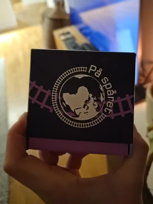 På spåret frågespel från Alga - Säljer ett På spåret frågespel från Alga, inspirerat av det populära TV-programmet. Lådan är svart och lila med tågräls och jordglob på framsidan. Spelet innehåller 800 frågor och passar för 2-6 spelare från 12 år. Perfekt för quizkvällar med vänner eller familj.